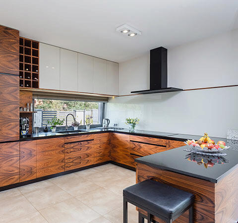 Nowoczesna kuchnia z drewnianymi frontami i wyspą.